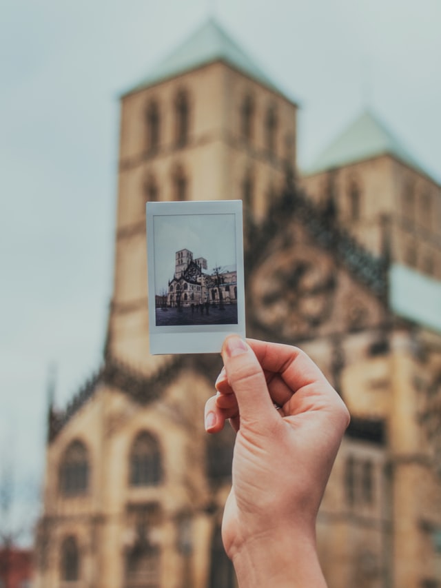 Münsteraner Dom im Hintergrund, Foto vom Dom mit Hand im Vordergrund