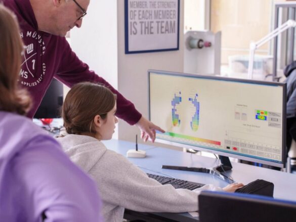 FH_GD_2023-pc Der professor erklärt einem Mädchen, das am PC sitzt die Messergebnisse.