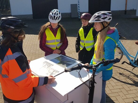 fahrradbuero-gd-2023-planungsgespraech Die drei Mädchen stehen rund um das Transportfahrrad der Radplanerin.