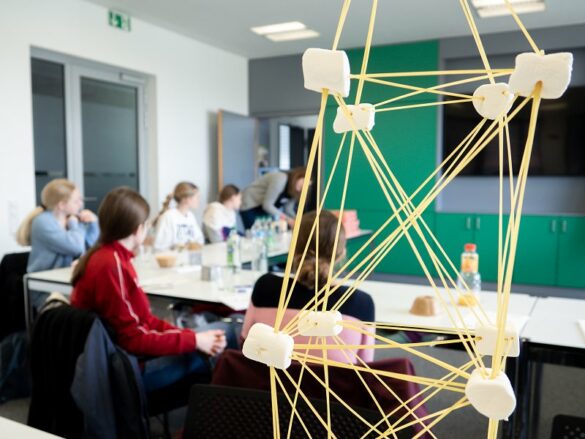 die Mädchen sitzen gemeinsam am Tisch und besprechen ihre Ergebnisse.