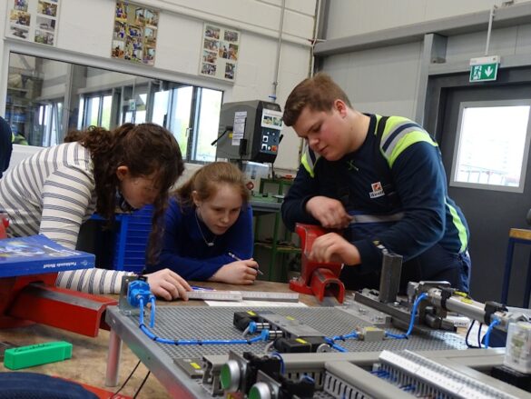 girlsday-2024-westfalen-ag-2 Ein Mitarbeiter erklärt zwei Mädchen einen Schaltkreis.