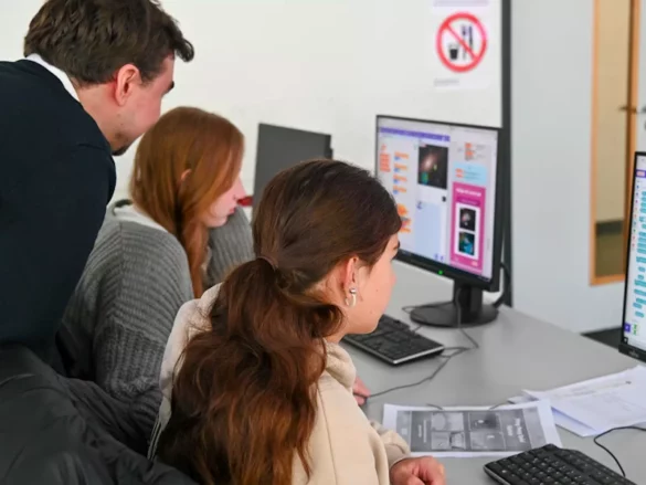 girlsday-fh-2024-3 Ein Mann und zwei Schülerinnen schauen auf einen Computerbildschirm.